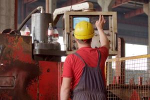 Workers monitoring machinery at an aluminum extrusion company.